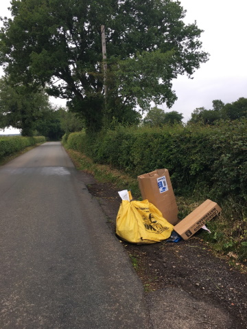hilderstone flytipping - yellow builders sack and cardboard boxes