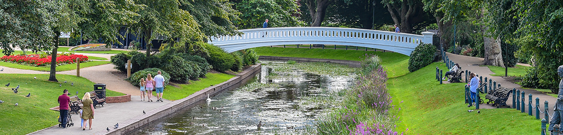 People walking along a canal with a bridge in Stafford