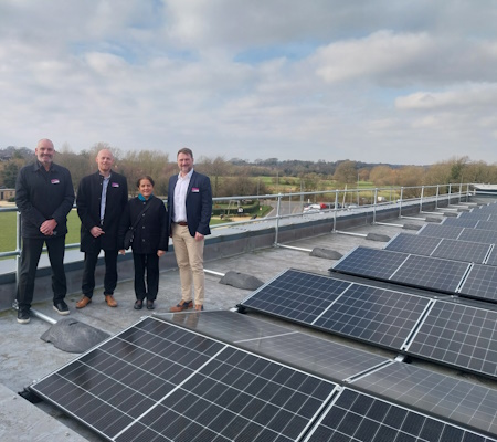 four people and solar panels